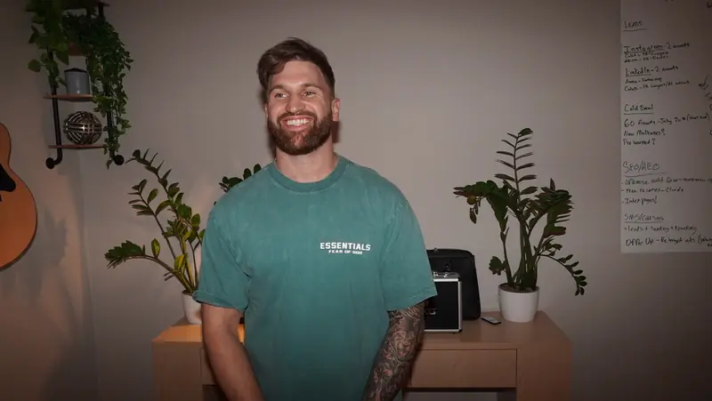 Caleb Hellinger smiling in his office beside a campaign whiteboard