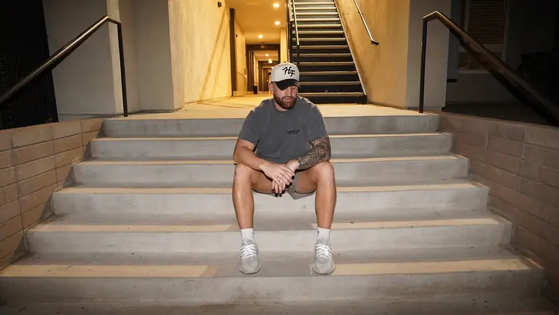 Caleb Hellinger seated on outdoor stairs