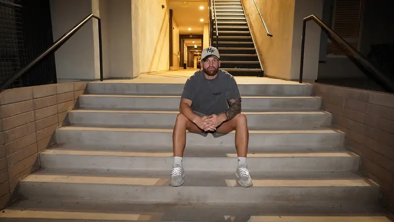 Caleb Hellinger sitting on apartment stairs at night in North Phoenix