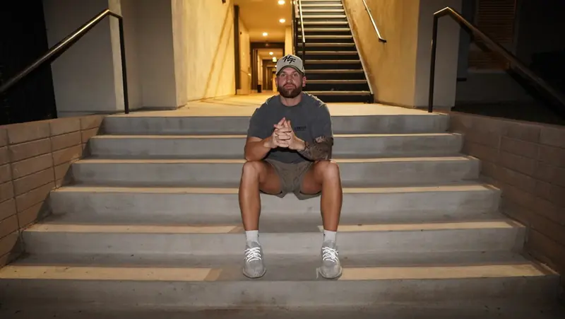 Caleb Hellinger seated centered on outdoor stairs