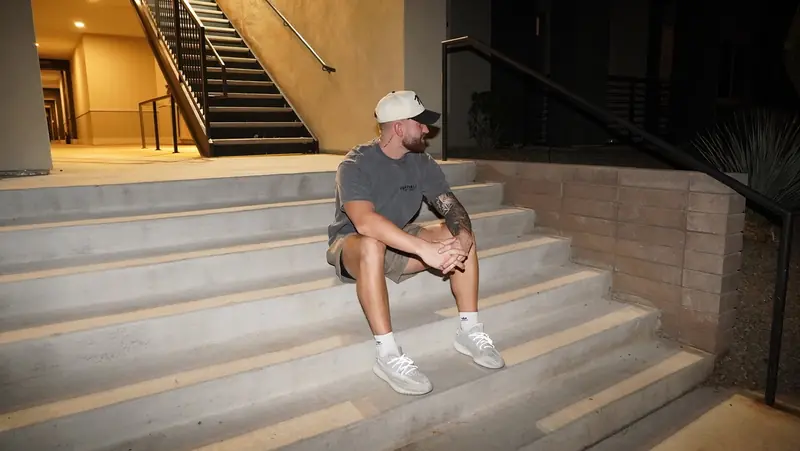 Caleb Hellinger seated on stairs, side angle