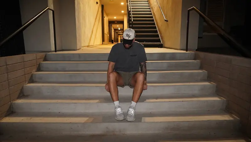 Caleb Hellinger on outdoor stairs, wide architectural frame