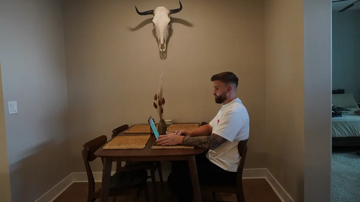 Caleb Hellinger working on a laptop at a dining table